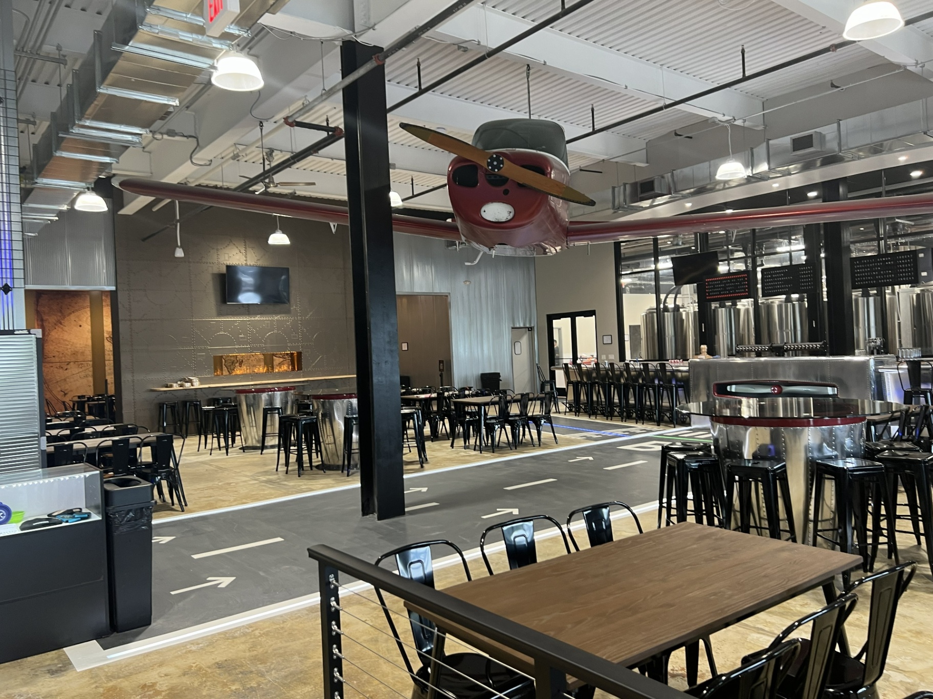 Bonesaw Brewing Deptford — taxiway graphics and drum-base high tables