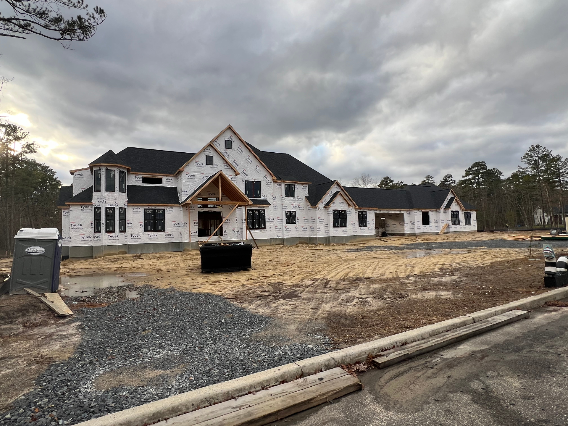Shamong Residence — framing and weather barrier at dusk
