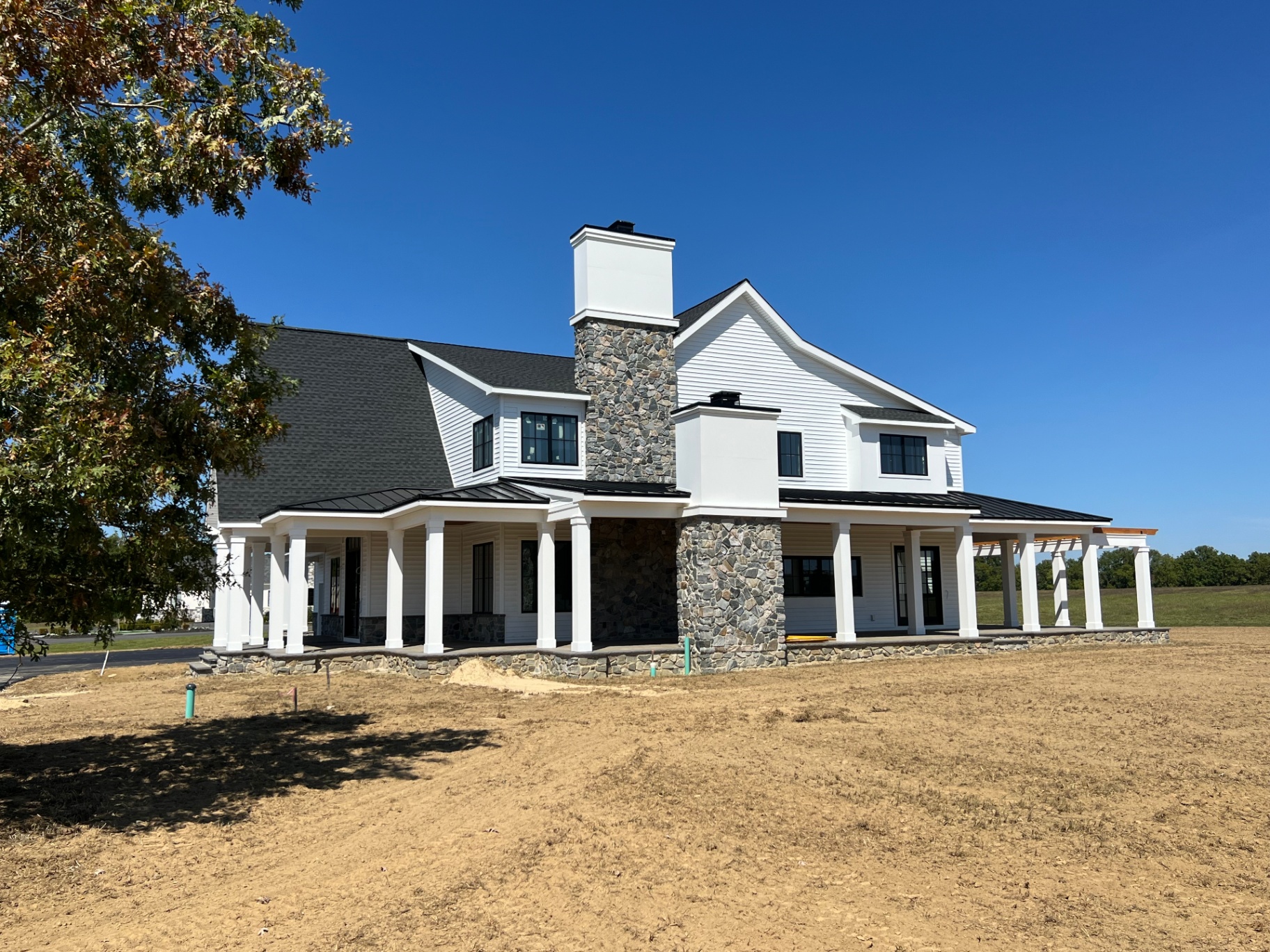 Woodstown Residence II — rear elevation with stone chimney and pergola
